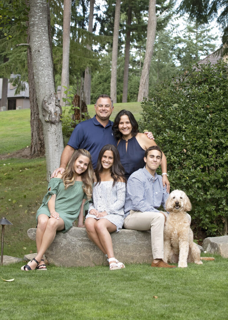 A family posing for a picture with their dog.